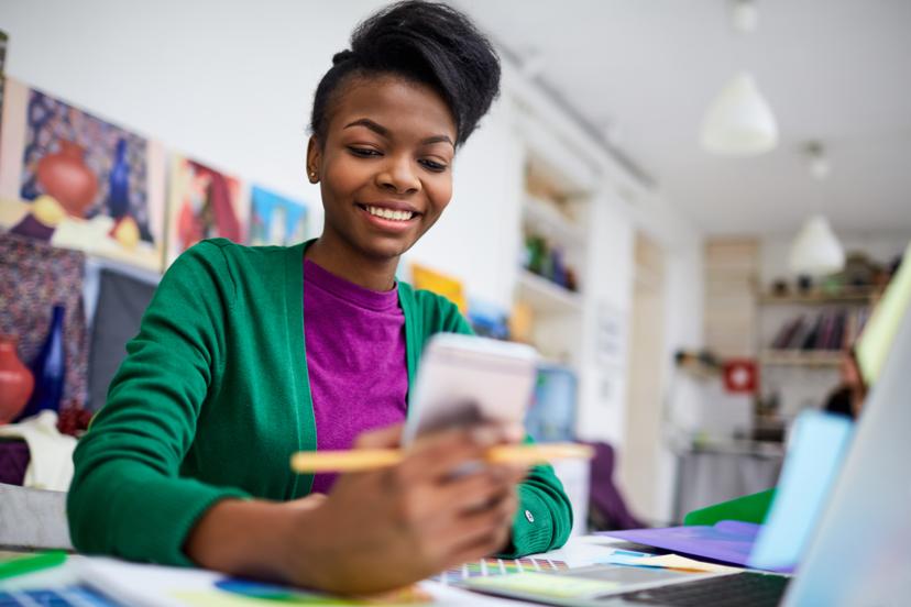 A lady looking at her phone and smiling
